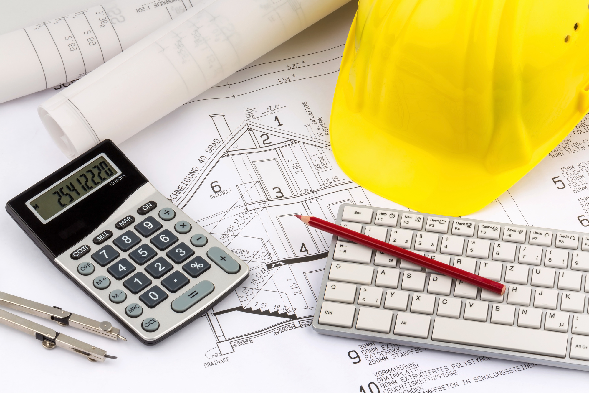 Ein Bauplan eines Architekten mit dem Bauhelm eines Bauarbeiters. Symbolfoto für Finanzierung und Planung eines neuen Hauses.